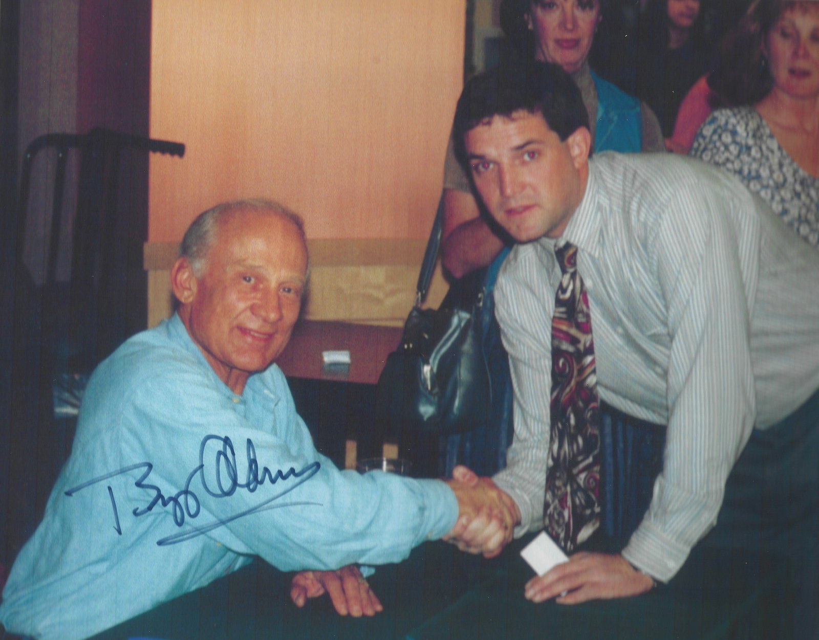 Buzz Aldrin and John Lang shaking hands at a signing table in Seattle in 1996.
