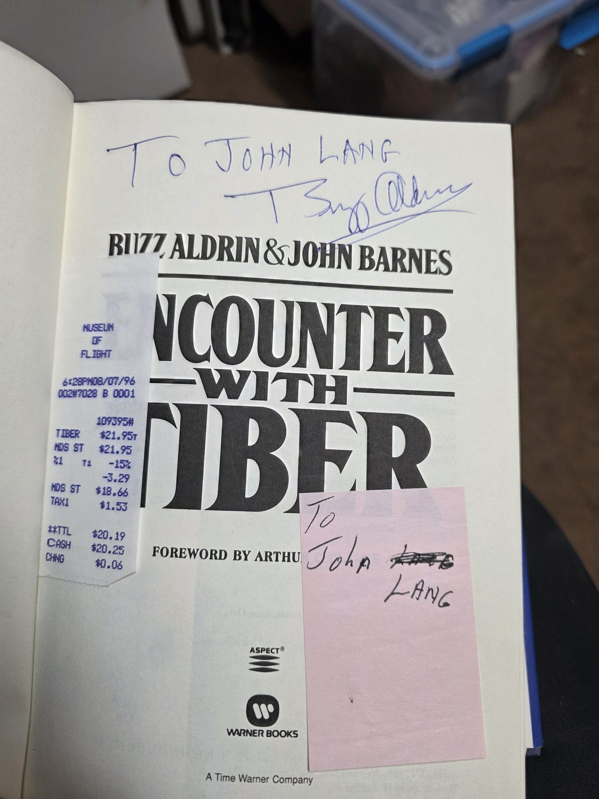 Title page of Encounter with Tiber inscribed To John Lang and signed by Buzz Aldrin, with a Museum of Flight receipt dated August 7, 1996 at 6:28 PM tucked in the gutter and a pink note in John's hand reading To John Lang.